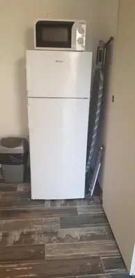 a refrigerator with a microwave on top of it in a room at Mini-villa 1 MER in Porto-Vecchio