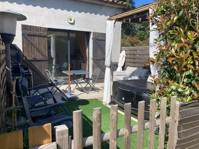 a backyard with a wooden fence and a grill at Mini-villa 2 MONTAGNE in Porto-Vecchio