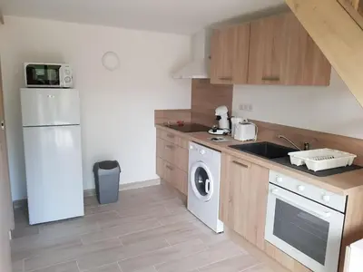 a kitchen with a white refrigerator and a dishwasher at Mini-villa 2 MONTAGNE in Porto-Vecchio