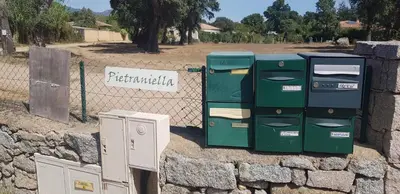 two old machines sitting next to a stone wall at Mini-villa 2 MONTAGNE in Porto-Vecchio