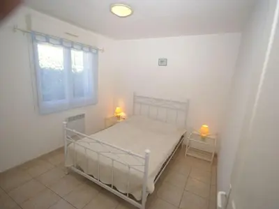 a bedroom with a bed and two lamps on two tables at Villa in Moriani-Plage near Sandy Beach in San-Nicolao