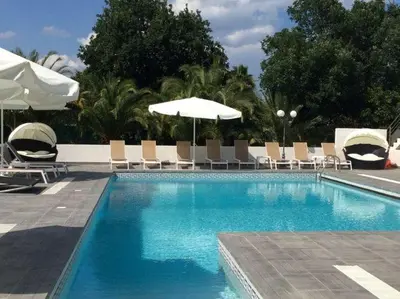 a large swimming pool with chairs and umbrellas at Villa in Moriani-Plage near Sandy Beach in San-Nicolao