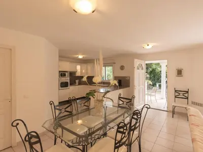 a dining room and kitchen with a glass table and chairs at Villa in Moriani-Plage near Sandy Beach in San-Nicolao