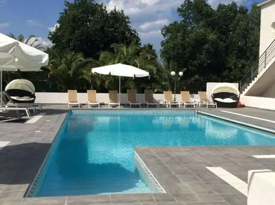 a large swimming pool with chairs and umbrellas at Apartment in Moriani-Plage near the Beach in San-Nicolao