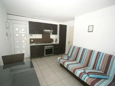 a living room with a couch and a kitchen at Holiday Home in Moriani-Plage near Beach in San-Nicolao