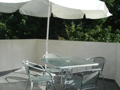 a table with two chairs and an umbrella at Holiday Home in Moriani-Plage near Beach in San-Nicolao