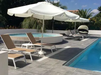a group of chairs and an umbrella next to a pool at Holiday Home in Moriani-Plage near Beach in San-Nicolao
