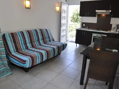 a living room with a couch and a kitchen at Holiday Home in Moriani-Plage near Beach in San-Nicolao