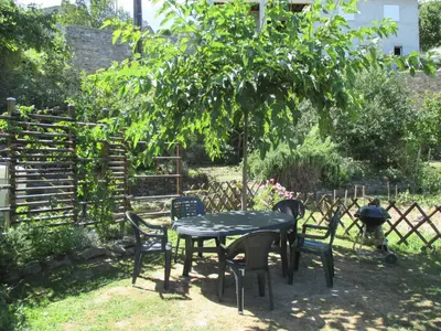 a table and chairs in a yard with a tree at Sole e Ventu (70 qm) in San-Giovanni-di-Moriani