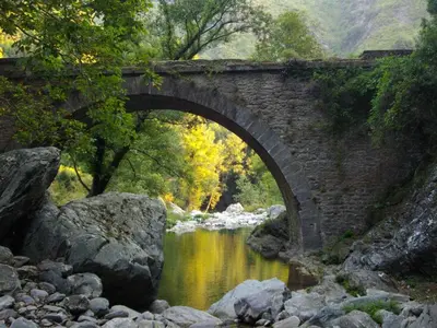an old stone bridge over a river with rocks at Sole e Ventu 30qm in San-Giovanni-di-Moriani