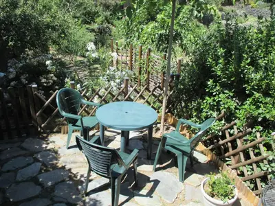 a blue table and chairs in a garden at Sole e Ventu 30qm in San-Giovanni-di-Moriani