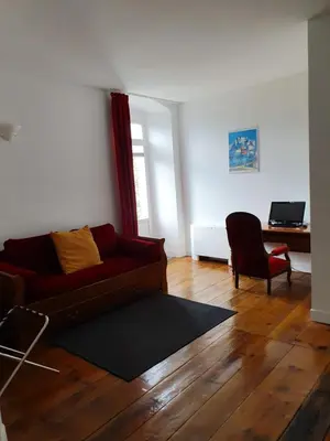 a living room with a red couch and a desk at Casa Guelfucci in Corte