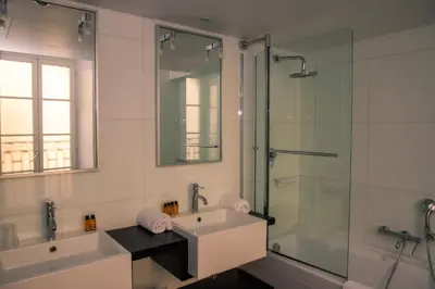 a bathroom with a sink and a glass shower at Hotel POZZO DI BORGO in Ajaccio