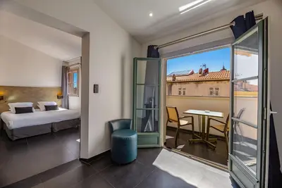 a hotel room with a bed and a room with a view at Hotel POZZO DI BORGO in Ajaccio