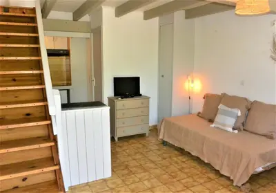 a bedroom with a bed and a tv and a staircase at CANELLA 2 in Favone