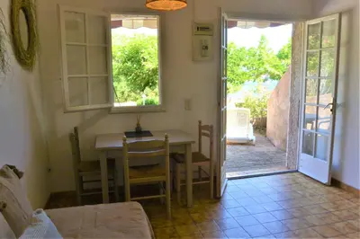 a dining room with a table and a door to a patio at CANELLA 2 in Favone