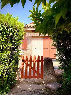 a red wooden fence in front of a house at CANELLA 3 in Favone