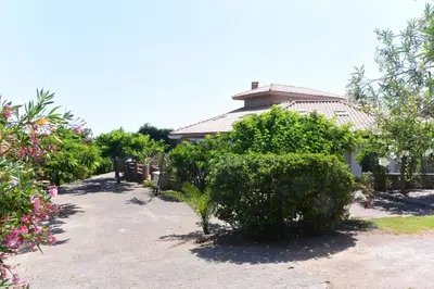 a house with a bush in front of a building at CANELLA 5 in Favone