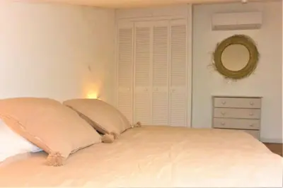 a bedroom with a bed with two pillows and a mirror at CANELLA 5 in Favone