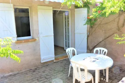 a patio with a table and chairs in front of a building at CANELLA 5 in Favone