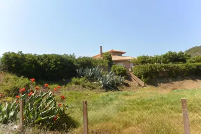a house on a hill with a fence and flowers at CANELLA 5 in Favone