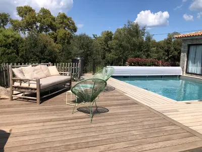 a patio with a couch and a chair next to a pool at villa rocca in Sotta