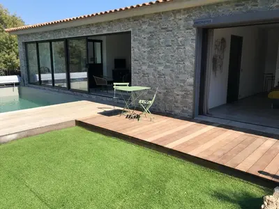 a patio with a table on a deck next to a house at villa rocca in Sotta