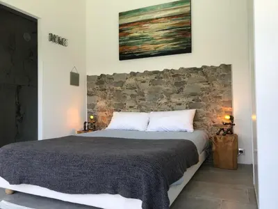 a bedroom with a bed with a stone wall at villa rocca in Sotta