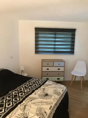 a bedroom with a bed and a dresser and a window at duplex vue mer exceptionnelle in Porticcio
