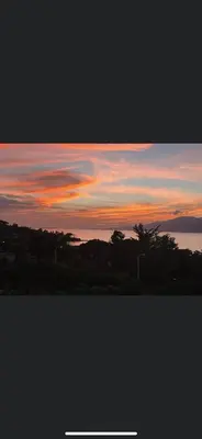 a view of a sunset with trees and clouds at duplex vue mer exceptionnelle in Porticcio