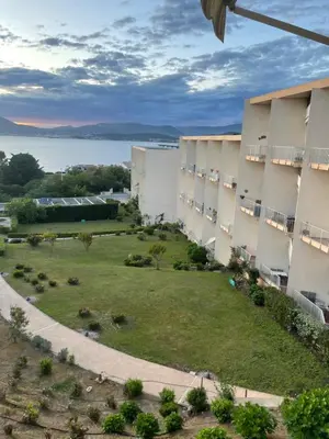 a view of a building with a green yard at duplex vue mer exceptionnelle in Porticcio