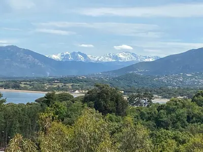 a view of snow capped mountains and a lake at duplex vue mer exceptionnelle in Porticcio