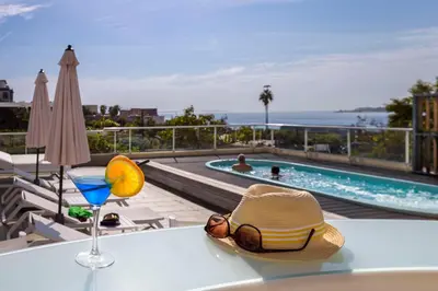 a table with a hat and a drink on top of a balcony at Best Western Plus Ajaccio Amirauté in Ajaccio