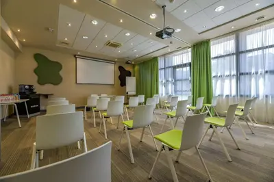 a conference room with white chairs and a whiteboard at Best Western Plus Ajaccio Amirauté in Ajaccio