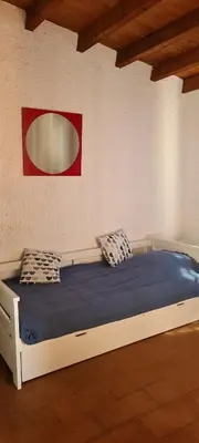 a bed in a room with a red picture on the wall at Villa Gasparini in Pietrosella