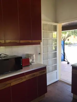 a kitchen with a microwave and a door to a yard at Villa Gasparini in Pietrosella