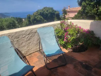 two blue chairs sitting on a patio with flowers at Villa Gasparini in Pietrosella