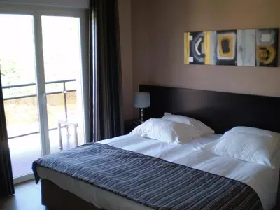 a bedroom with a large bed with a large window at Augustin Marie in Bonifacio