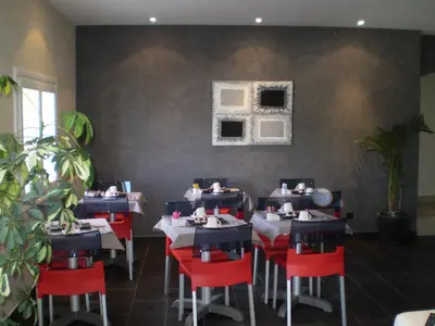 a dining room with tables and red chairs at Augustin Marie in Bonifacio