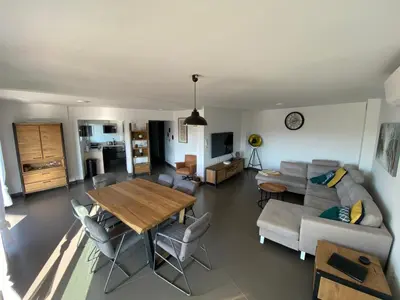 a living room with a table and a couch at Le Haut de la Vague in Porto-Vecchio