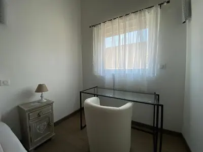 a room with a glass table and a chair and a window at Le Haut de la Vague in Porto-Vecchio