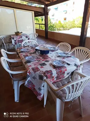 a dining room table with chairs and a table cloth at U Palmu in Sagone