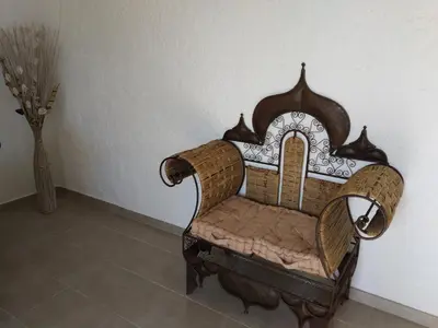 a chair sitting in a room next to a wall at U Palmu in Sagone