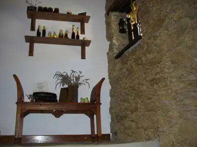 a room with wooden shelves and a table and a stone wall at Sole e Ventu 50qm in San-Giovanni-di-Moriani