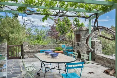 a patio with a table and chairs under a pergola at Casa La Colombaia in Poggio-di-Nazza