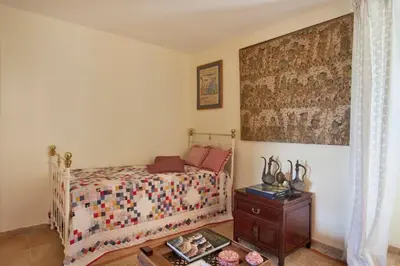 a bedroom with a bed and a wooden table at Casa La Colombaia in Poggio-di-Nazza
