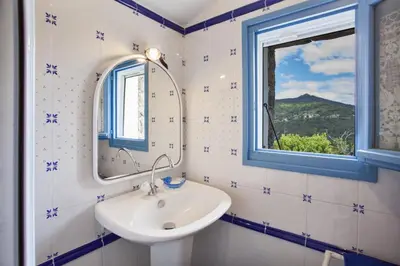 a bathroom with a sink and a mirror at Casa La Colombaia in Poggio-di-Nazza