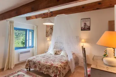 a bedroom with a bed with a mosquito net at Casa La Colombaia in Poggio-di-Nazza