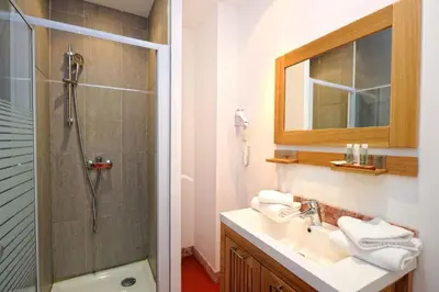 a bathroom with a shower and a sink and a mirror at Appartement du Tourisme in Zonza