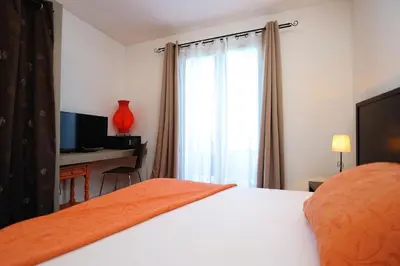 a bedroom with a bed and a desk and a window at Appartement du Tourisme in Zonza